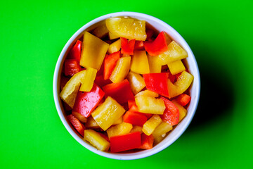 A Bowl Of Fresh Chopped Raw Uncooked Yellow And Red Peppers