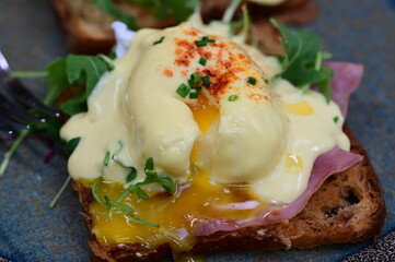 Eggs benedict with rucola and hollandaise sauce