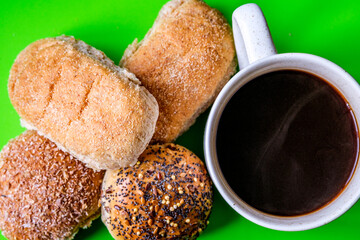 Selection Or Group Of Baked Mixed Mini Bread Rolls With A Mug Of Black Coffee Beverage