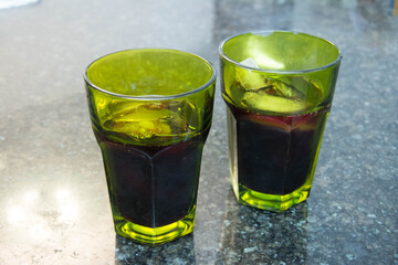 Two glasses with cola on a marble table in a restaurant