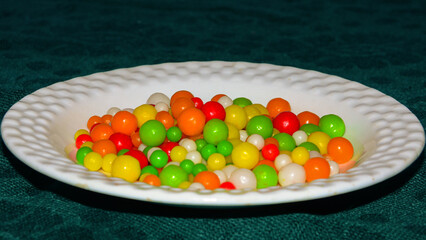 bright multicolored delicious and edible fruit flavored candy balls on white plate	