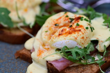 Eggs benedict with rucola and hollandaise sauce