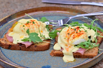 Eggs benedict with rucola and hollandaise sauce
