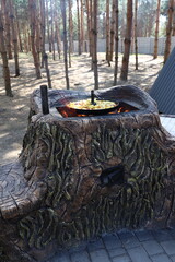 Rustic outdoor cooking of sliced potatoes in a pan over an open fire in a stone oven. Camp-style...