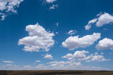 White airy clouds in a blue sky. Summer fluffy clouds, Beautiful sky with clouds, background for your projects.