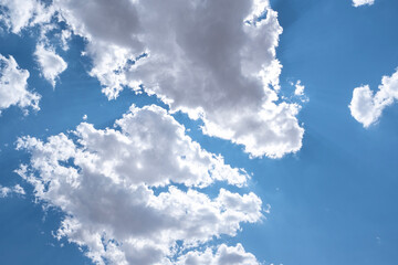 White airy clouds in a blue sky. Summer fluffy clouds, Beautiful sky with clouds, background for your projects.