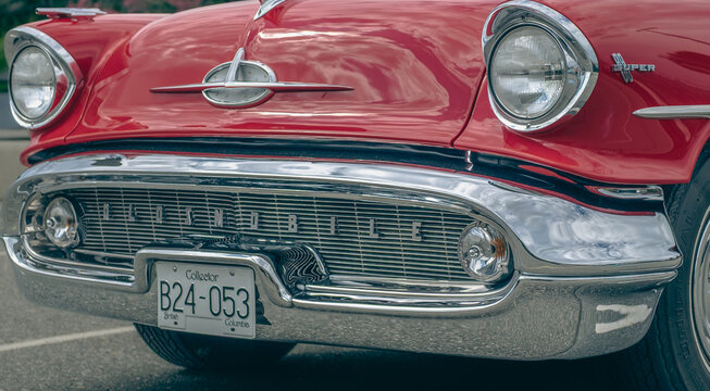 Front view of red oldsmobile car parked in the street