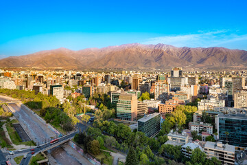 Santiago, Chile - January 02, 2025: Providencia's buildings line the Mapocho River, all set against the stunning backdrop of the Andes in the summer.