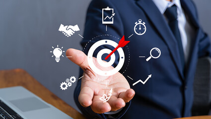 A businessman is presenting a target goal with business strategy icons to achieve success and growth