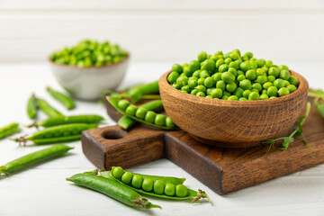 Fresh green pea pods with green peas on a wooden background. Sweet green peas. Green pea beans vegetables. Vegan. healthy vegetable. Copy space
