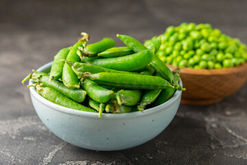 Fresh green pea pods with green peas on a wooden background. Sweet green peas. Green pea beans vegetables. Vegan. healthy vegetable. Copy space