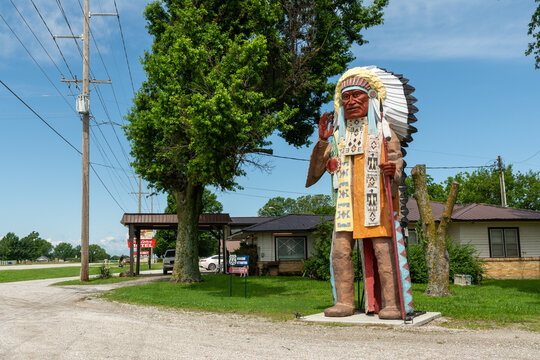 Vinita, Oklahoma, USA - June 18th 2025 - A 20ft tall Native American Indian wooden statue. located outside the famous route 66 roadside attractions of The Hi-Way Cafe and the Western Motel.
