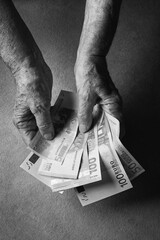 Euro banknotes in an adult woman hands. Selective focus, toned image, black and white