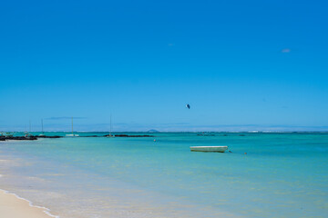 Fototapeta premium Beautiful landscape of Tropical Paradise - Belle Mare Beach with turquoise water. White boat in the Indian Ocean. Mauritius Island. Travel and vacation concept. Selective focus, blurred background.