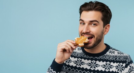A happy man takes a bite of a gingerbread cookie, enjoying the festive season.