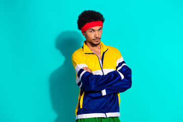 Young man in vintage sportswear with retro vibes against a vibrant teal background exuding...