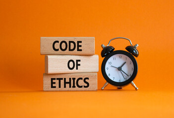 Code of ethics symbol. Concept words Code of ethics on wooden blocks with alarm clock. Beautiful...
