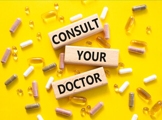 Consult Your Doctor symbol. Concept word Consult Your Doctor on wooden blocks. Beautiful yellow...
