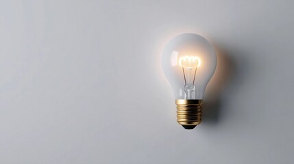 Bright light bulb glowing against a neutral background, symbolizing innovation and creativity in modern design