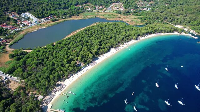 Best beautiful beaches of Skiathos island (Sporades) - white sandy Koukounaries beach popular tourist destination. High angle 4k hd drone video of natural park with lagoon and pine trees