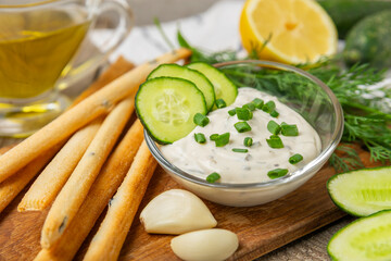 Cucumber sour cream tzatziki sauce on a wooden table.Tartar sauce. Traditional delicious appetizer....