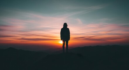 Silhouette of a person standing on a mountain peak against a vibrant sunset, capturing the essence of adventure, solitude, and the beauty of nature in a scenic landscape.