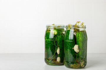 Freshly-salted homemade cucumbers in a jar on a wooden background. pickled cucumbers with dill,garlic and pepper.canned cucumbers.cucumbers and dill.Recipe of homemade preservations.fermented veggies.