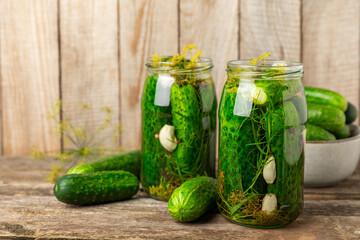 Freshly-salted homemade cucumbers in a jar on a wooden background. pickled cucumbers with dill,garlic and pepper.canned cucumbers.cucumbers and dill.Recipe of homemade preservations.fermented veggies.