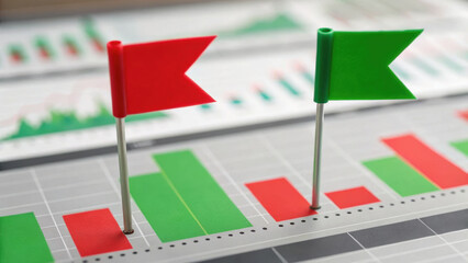 Financial dashboard displays red and green flags on bar graphs, indicating performance metrics. close up view highlights data analysis and market trends, emphasizing financial insights
