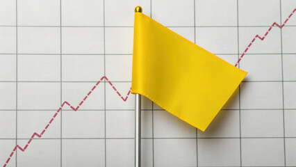 Yellow flag is placed on financial graph with sharp dip, symbolizing caution in market trends. graph red line indicates fluctuations, highlighting potential risks
