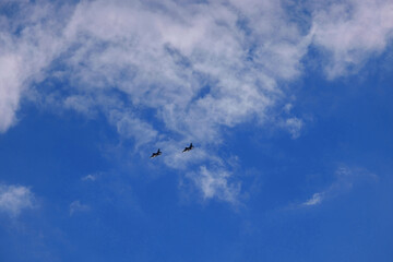 Pair of Military Fighter Aircraft in Formation Flight Against Blue Sky