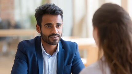 Indian male hr specialist manager, employer, boss listening female latin candidate at job interview, consulting client at office meeting. Hiring and employment, human resources, recruitment concept.,