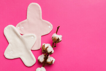 set of colorful bright reusable menstrual pads with cotton flower. zero waste woman periods concept...