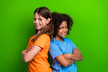 Smiling classmates with crossed arms standing against a green background representing happiness