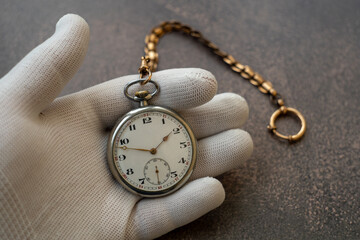 Antique pocket watch.Antique watch in hand with a white glove.