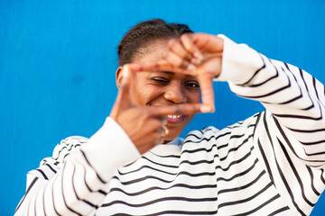 Smiling African woman making frame gesture with fingers
