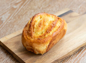 Golden Coconut Custard Pillow Bread on Wooden Board side view of Sweet Bakery Treat