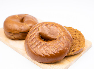 Toasted Pumpernickel Bagel Dark Rye Bread on wooden board isolated on white background side view of Breakfast