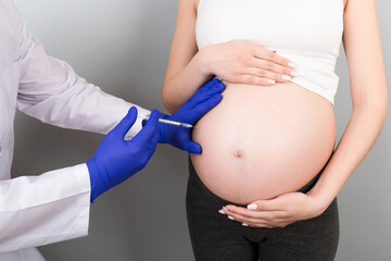 Newborn family concept. A pregnant woman with the hand of a doctor to vaccinate ,nurse vaccinating...