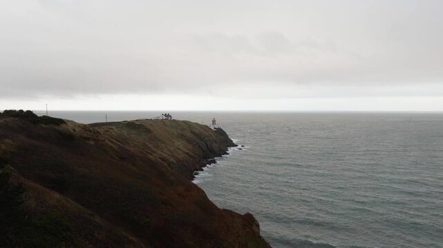 Aerial footage of Baily Lighthouse in Howth, Dublin, Ireland on a windy and cloudy day in October. Ship passing by the lighthouse.