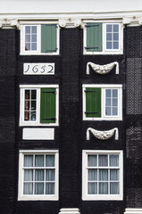 Obraz premium Closeup detail of colorful windows and shutters, a unique Dutch architectural feature on apartment buildings in Amsterdam, Holland, The Netherlands.
