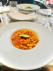 Traditional Italian pasta all’Amatriciana served in a white bowl. Short rigatoni pasta covered...