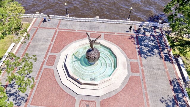 Aerial view of a sculpture of winged angel standing atop a globe fountain on a brick square near the water, Jacksonville, Florida, United States.