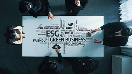 A team of professionals collaborating around a table, focusing on green business strategies and ESG...