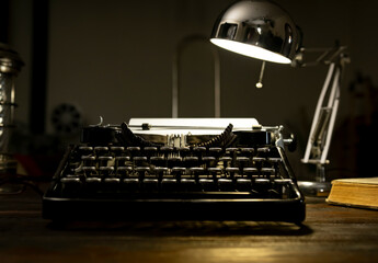 Vintage typewriter illuminated by a desk lamp in a cozy writing space during the evening hours