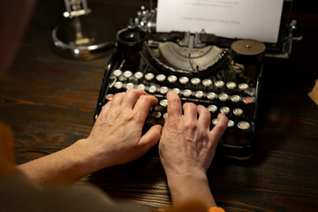 Person using a vintage typewriter to create written work in a cozy workspace setting