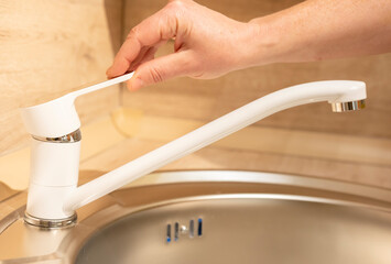 Modern kitchen faucet installation process with a hand adjusting the water flow in a cozy home...