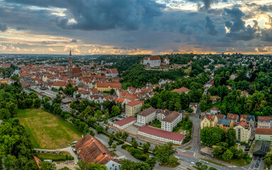 Naklejka premium Aerial view of Landshut medieval German town on the Isar river in Bavaria with restored Trausnitz castle, dramatic sunset sky