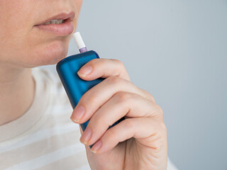 Caucasian woman smoking electronic cigarette. Tobacco heating system.