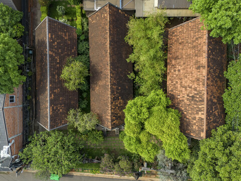 Aerial view of rooftops, a mosaic of terracotta contrasting with the lush green canopy, creating a vibrant urban tapestry, Buon Ma Thuot, Dak Lak, Vietnam.